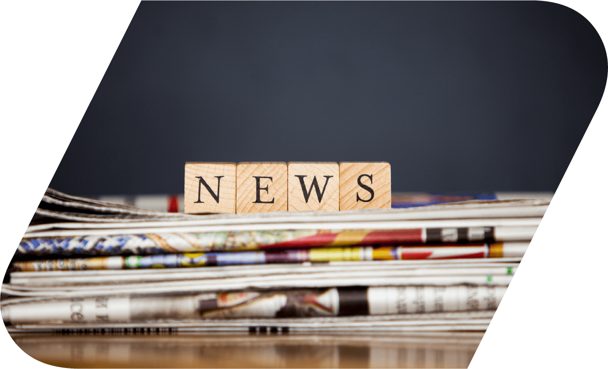 Four wooden blocks on newspapers spelling out news.