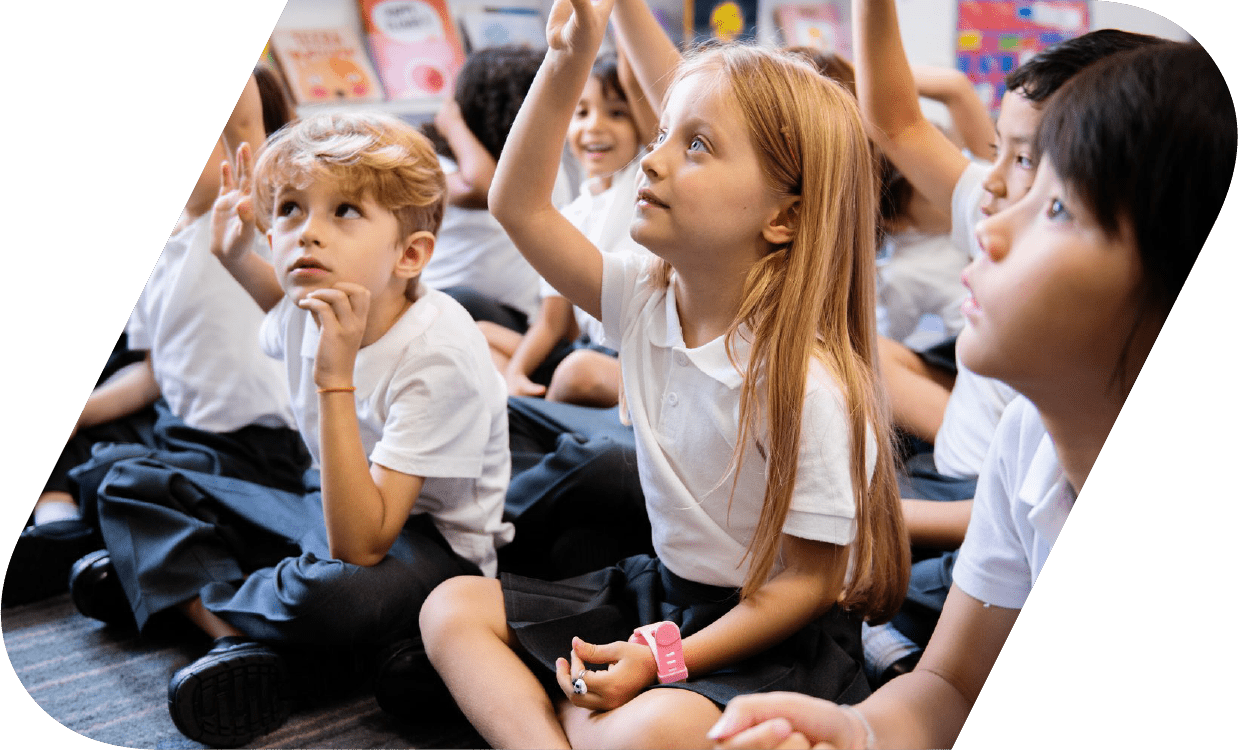 School kids raising their hands to answer a question.