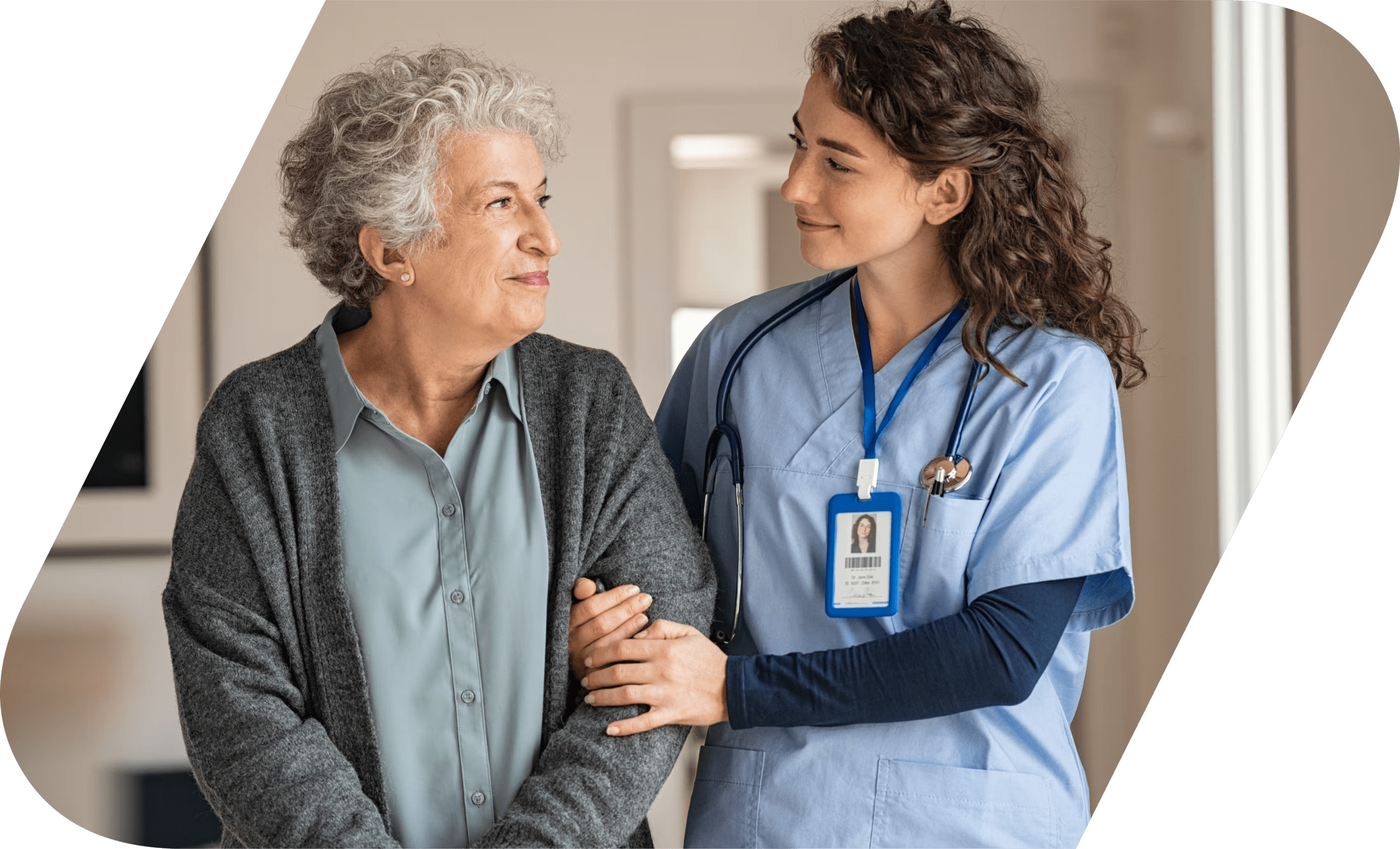 An elderly lady taking a walk with a female nurse at a nursing home.