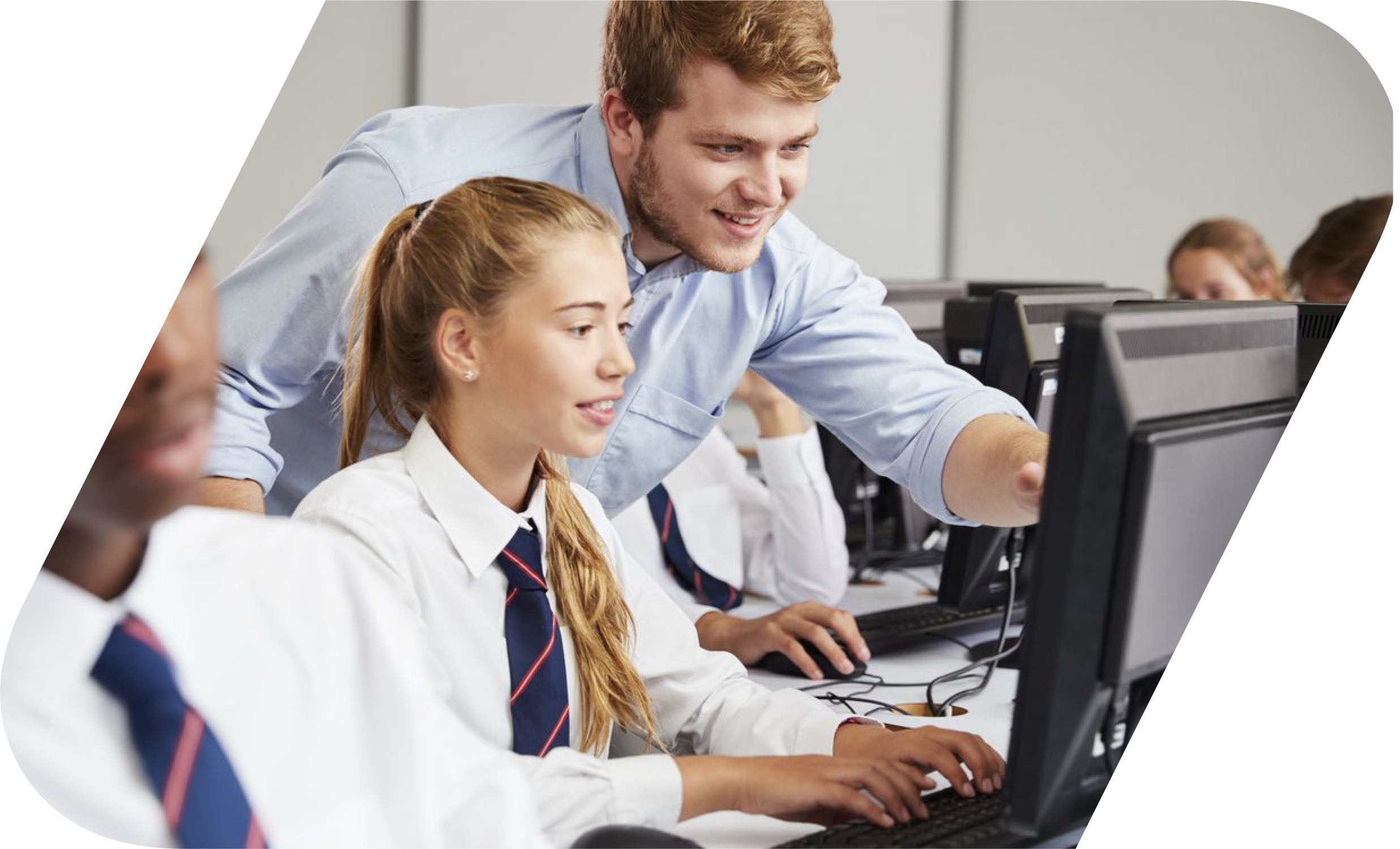 A student being assisted by a teacher in front of a computer.